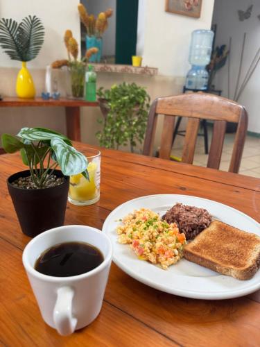 a plate of food with toast and a cup of coffee at La Posadita de Bolonia in Managua