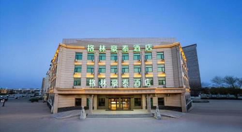 a building with a sign on the front of it at GreenTree Inn Puyang Pushang Huanghe Road in Puyang
