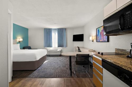 a hotel room with a bed and a kitchen at MainStay Suites Salt Lake City Fort Union in Midvale