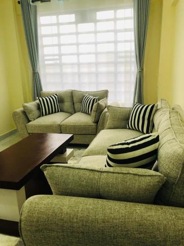 a living room with two couches and a table at The hideout in Ruiru