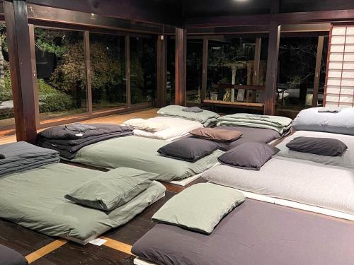 a group of mattresses lined up in a room at Yado Nishimura Timeless Japan Experience in Shizuoka