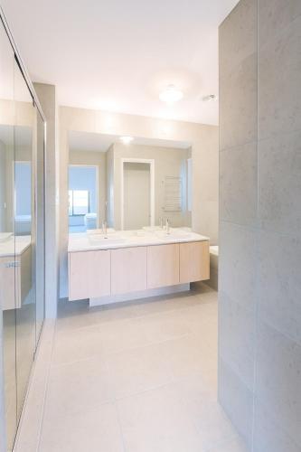 a bathroom with two sinks and a large mirror at CasaAria - Modern, Contemporary, Luxe Linens in Truganina