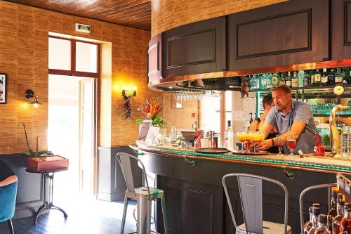 a man preparing a drink at a bar at Résidence Château de Salles in Salles
