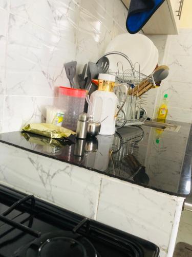 a counter top with dishes and bottles on it at The hideout in Ruiru
