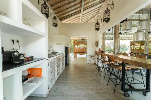 eine Küche und ein Esszimmer mit einem langen Tisch und Stühlen in der Unterkunft Beach Villas Lombok in Tanjung