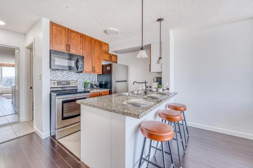 a kitchen with a counter and two bar stools at Central City Location, Bay View, One Free Parking in Vancouver