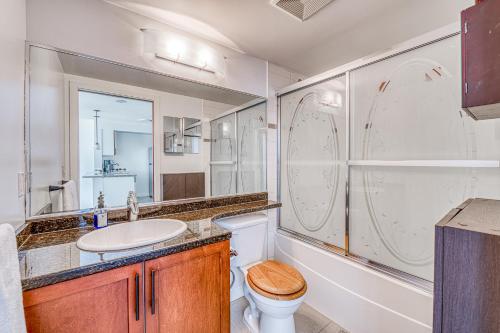 ein Badezimmer mit Toilette, Waschbecken und Spiegel in der Unterkunft Central City Location, Bay View, One Free Parking in Vancouver