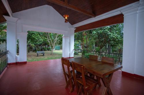 a dining room with a wooden table and chairs at Villa De Sal in Galle