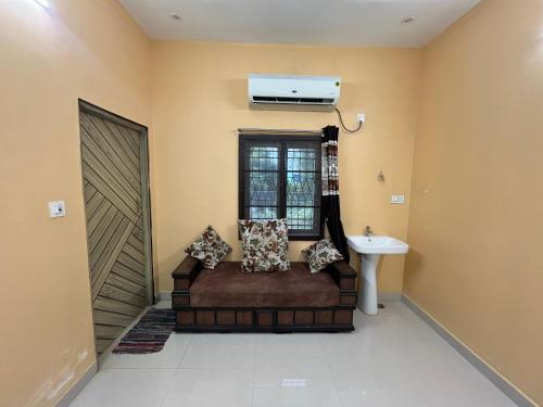a living room with a couch and a window and a air conditioner at GYANi 1 in Tiruvannāmalai