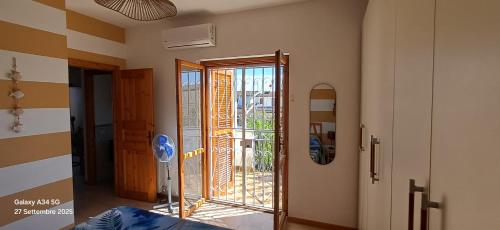 a room with a sliding glass door with a balcony at Ylenia Summer Beach in LʼAmericano