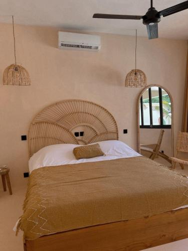 ein Schlafzimmer mit einem großen Bett mit einem hölzernen Kopfteil in der Unterkunft BAYA - Modern & Cozy 2BR Villa Uluwatu in Bingin Beach