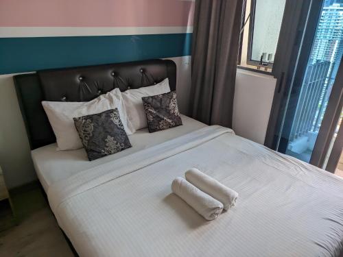a bed with a white towel laying on it at The Luxe & Colony Infinitum KLCC by CoupleStay in Kuala Lumpur