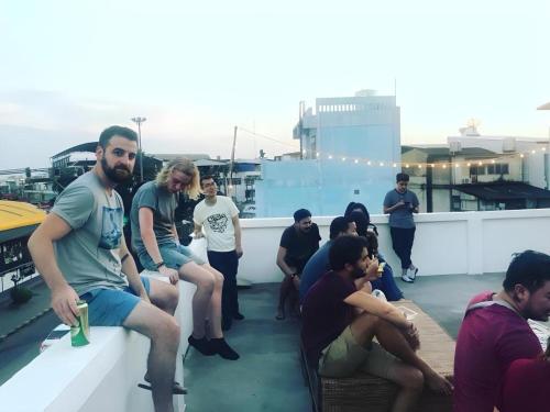 a group of people sitting on a roof at Oldie and Sleepy Hostel in Udon Thani