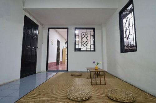 an empty hallway with a table and two windows at OK hostel in Luang Prabang
