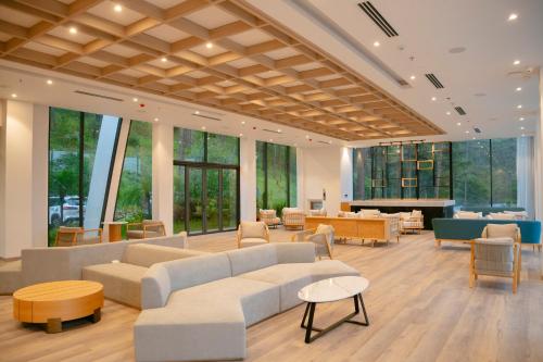 a living room with couches and tables and windows at Haven in the Pines in Ðinh An (2)