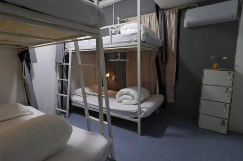a room with two bunk beds with white pillows at OK hostel in Luang Prabang