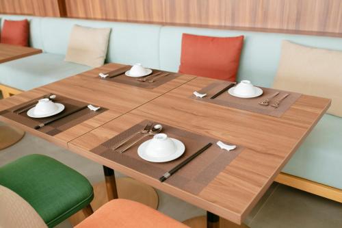 a wooden table with plates and bowls on it at Haven in the Pines in Ðinh An (2)