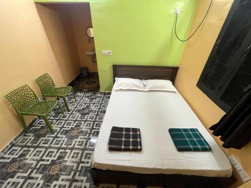 a bed in a room with green walls and chairs at Gyani 3 in Tiruvannāmalai