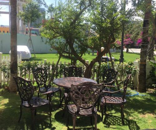 a table and chairs in a yard with a tree at Wonderland Hồ Tràm - Mocha Viva in Ho Tram