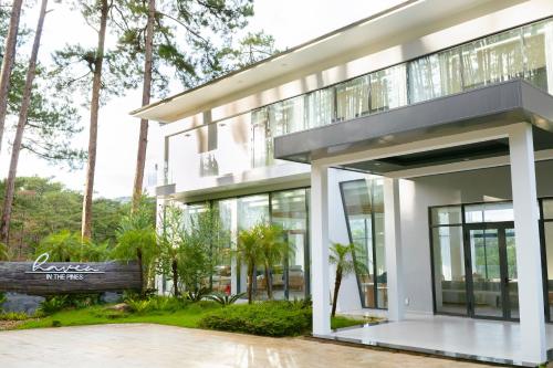 a modern house with glass doors and trees at Haven in the Pines in Ðinh An (2)