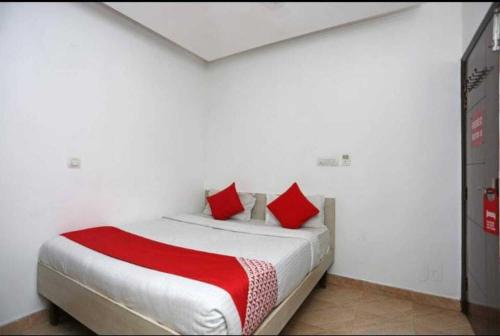 a bedroom with a large bed with red pillows at Birr Residency - Near Nizamuddin in New Delhi
