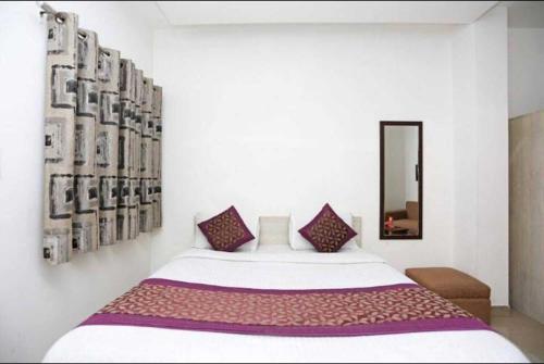 a bedroom with a large bed and a mirror at Birr Residency - Near Nizamuddin in New Delhi
