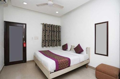a bedroom with a bed and a chair in it at Birr Residency - Near Nizamuddin in New Delhi