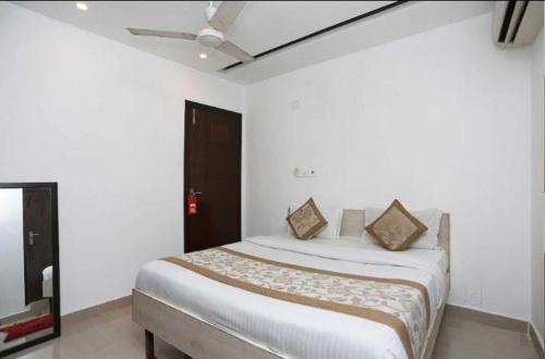 a bedroom with a bed in a white room at Birr Residency - Near Nizamuddin in New Delhi