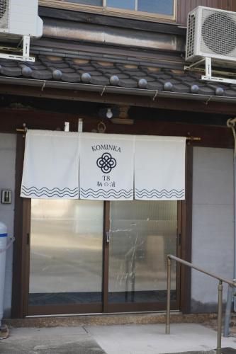a white sign on the front of a building at KOMINKA T8 Tomonoura in Fukuyama