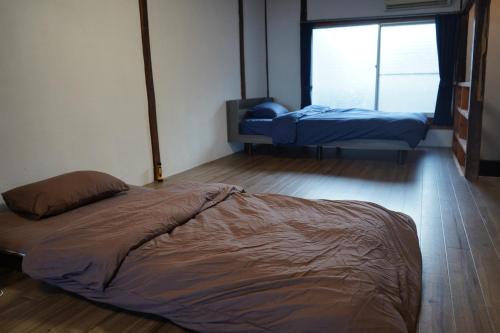 a bedroom with two beds in a room at KOMINKA T8 Tomonoura in Fukuyama