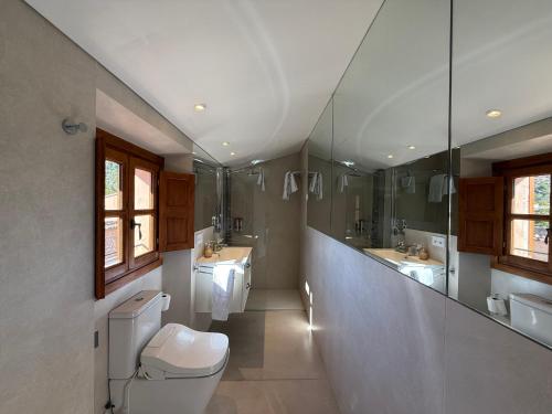 a bathroom with a toilet and two sinks and a mirror at Marton Valldemossa Turismo de Interior in Valldemossa