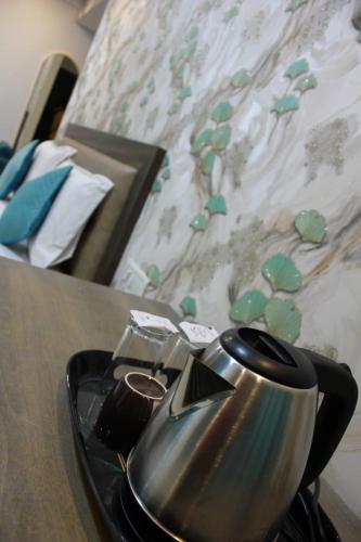 a tea kettle on a table next to a bed at Vaishnavi Suites in Bengaluru