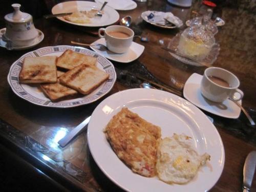 a table with plates of food and cups of coffee at Majestic empire group of houseboat in Srinagar