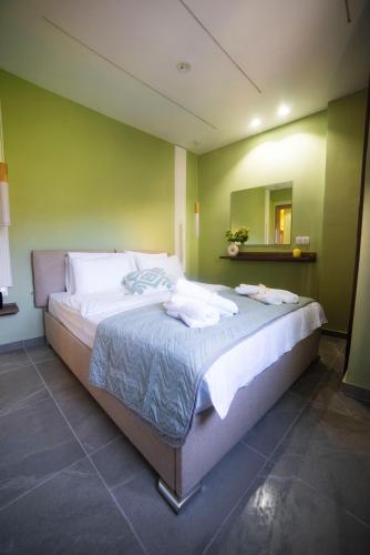 a large bed in a room with a green wall at Coloris Viridis room in Thessaloniki