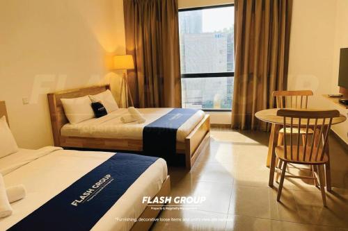 a hotel room with two beds and a table and chairs at Forte Seasons Mossaz Premium Suites Petaling Jaya in Petaling Jaya