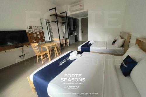 a bedroom with a bed with a blue and white comforter at Forte Seasons Mossaz Premium Suites Petaling Jaya in Petaling Jaya