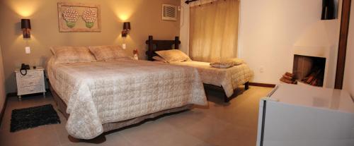 a bedroom with two beds and a tv in it at Hotel Daniela in Penedo