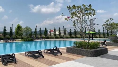 a swimming pool with chaise lounges next to a resort at TSYLuxeLoft 4BR Near UKM & Bangi Toll in Bandar Baru Bangi