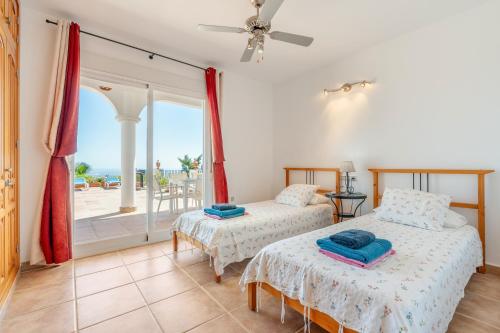 two beds in a room with a view of the ocean at Villa Las Brisas in Salobreña