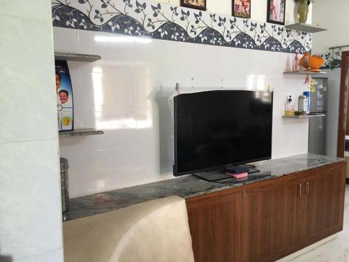 un téléviseur à écran plat posé sur un meuble en bois dans l'établissement Golden Gate 2bhk Serviced Apartment Mangadu, à Chennai