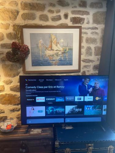 a computer screen with a picture on a wall at Gîtes d Izel N1 entre terre et mer prés d'un golf in Ploemel