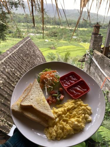 a plate of food with eggs and toast and ketchup at Natural View Sidemen in Silebeng
