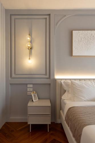a bedroom with a bed and a light on the wall at Penthouse The Olaf at Chiang Mai's Old Town Suandok Gate I Entire Villa Booking I 4 Bedrooms I in Chiang Mai