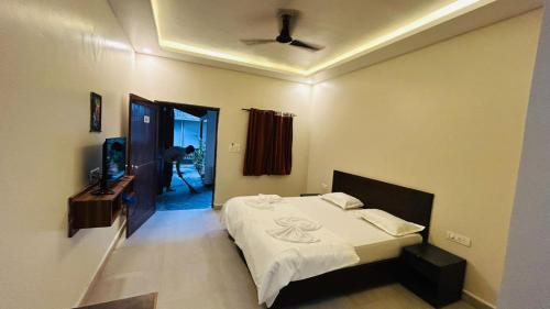 a bedroom with a bed and a television in it at Claudina baga beach in Calangute
