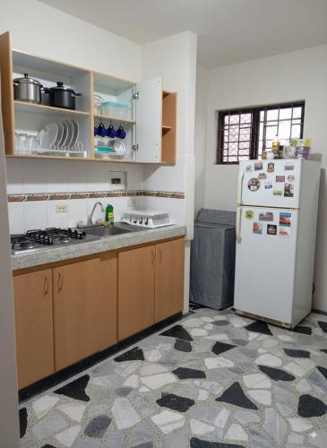 a kitchen with a white refrigerator and a tile floor at Fuera de Casa como en Casa in Manizales