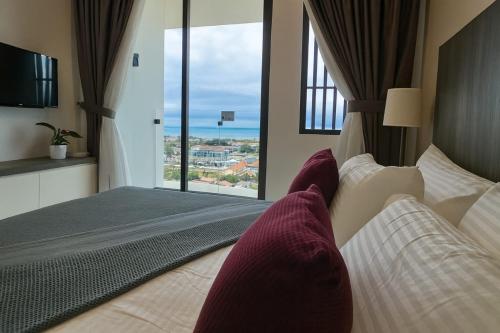a hotel room with a bed and a large window at PD D'Wharf High Floor Studio With Private Entrance And Seaview Balcony in Port Dickson