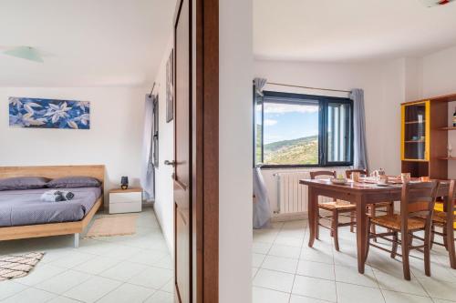 a bedroom and a dining room with a table and a bed at Casa Cuccureddu in Jerzu