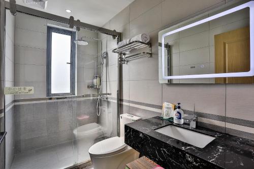 une salle de bain avec un lavabo, des toilettes et un miroir dans l'établissement Yinshu Lunasvilla Courtyard Garden Resort Hotel, à Shanghai