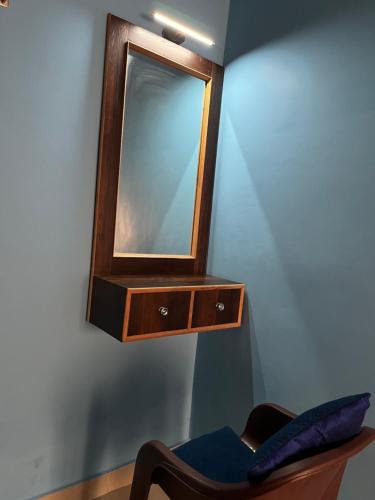 a mirror hanging on a wall next to a chair at Kailash Dham in Varanasi