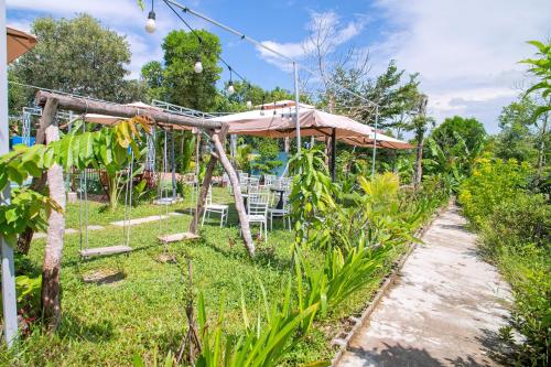 a garden with a table and chairs under a umbrella at Memories Hoi An Villa in Hoi An